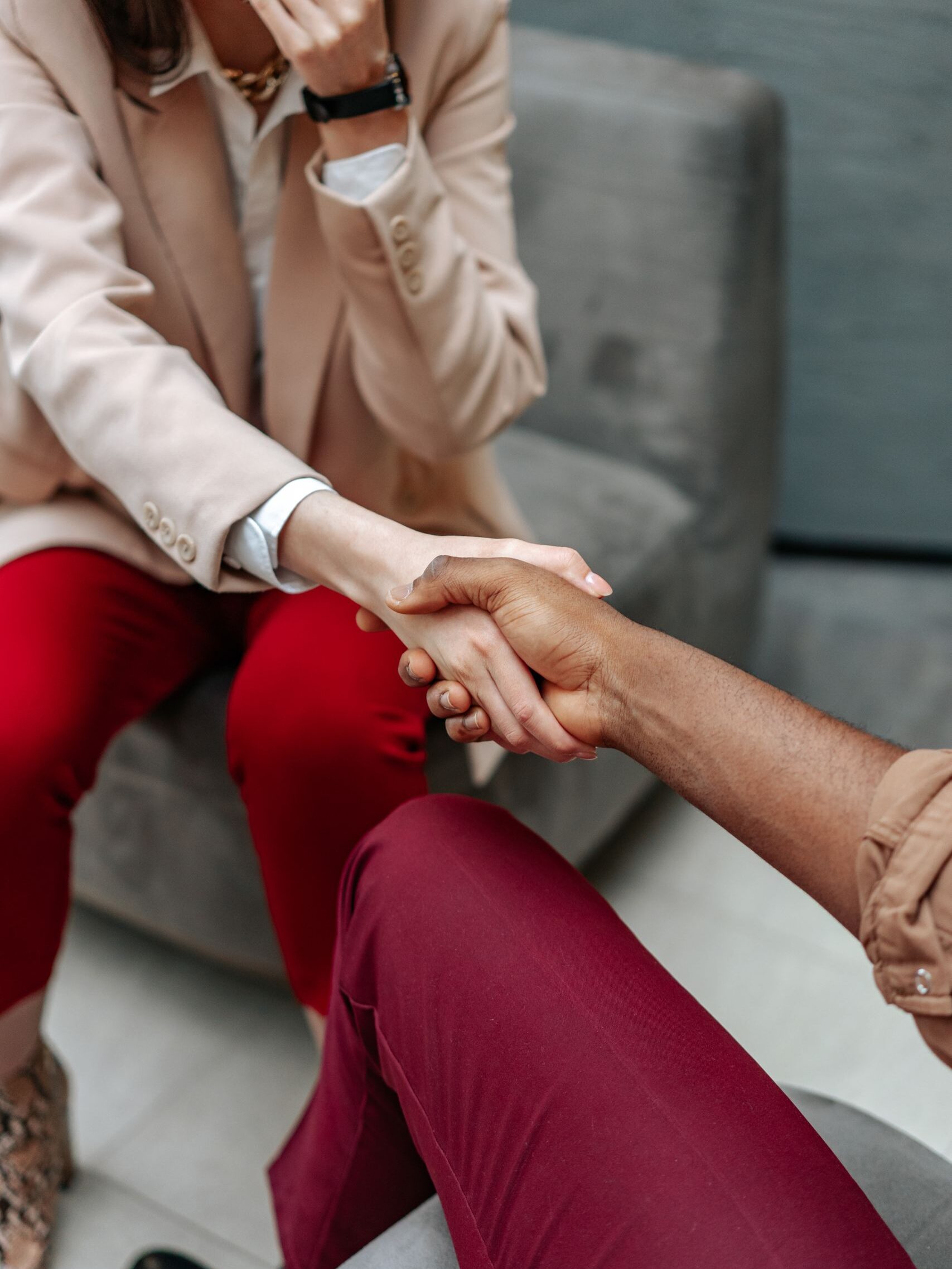 Two professionals shaking hands indoors, symbolizing agreement and collaboration.
